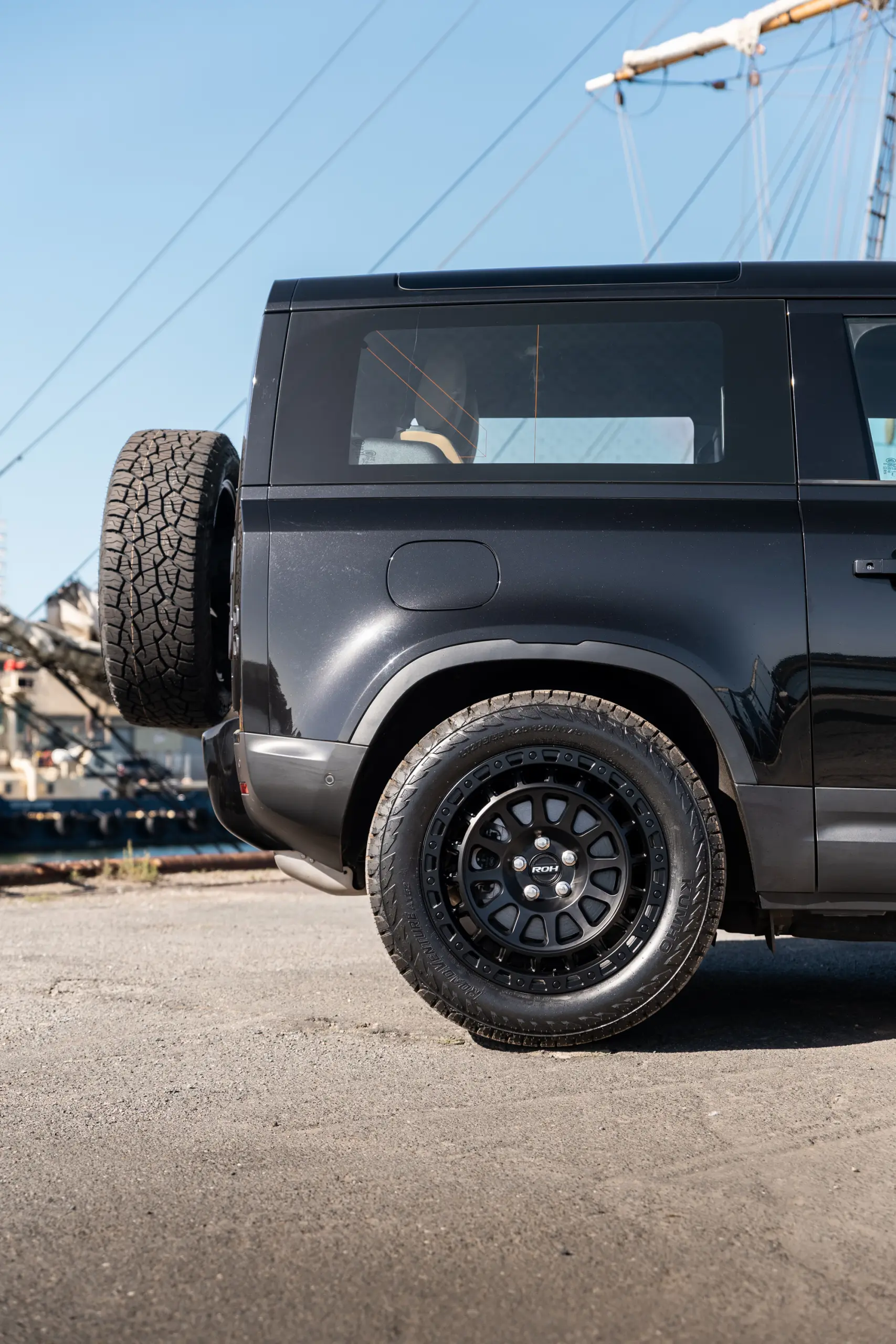 Black Land Rover Defender 90 with 20x9 +22 5x120 Matte Black ROH Assault Wheels at dockyard