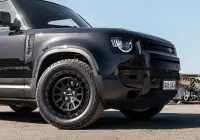 Black Land Rover Defender 90 with 20x9 +22 5x120 Matte Black ROH Assault Wheels at dockyard