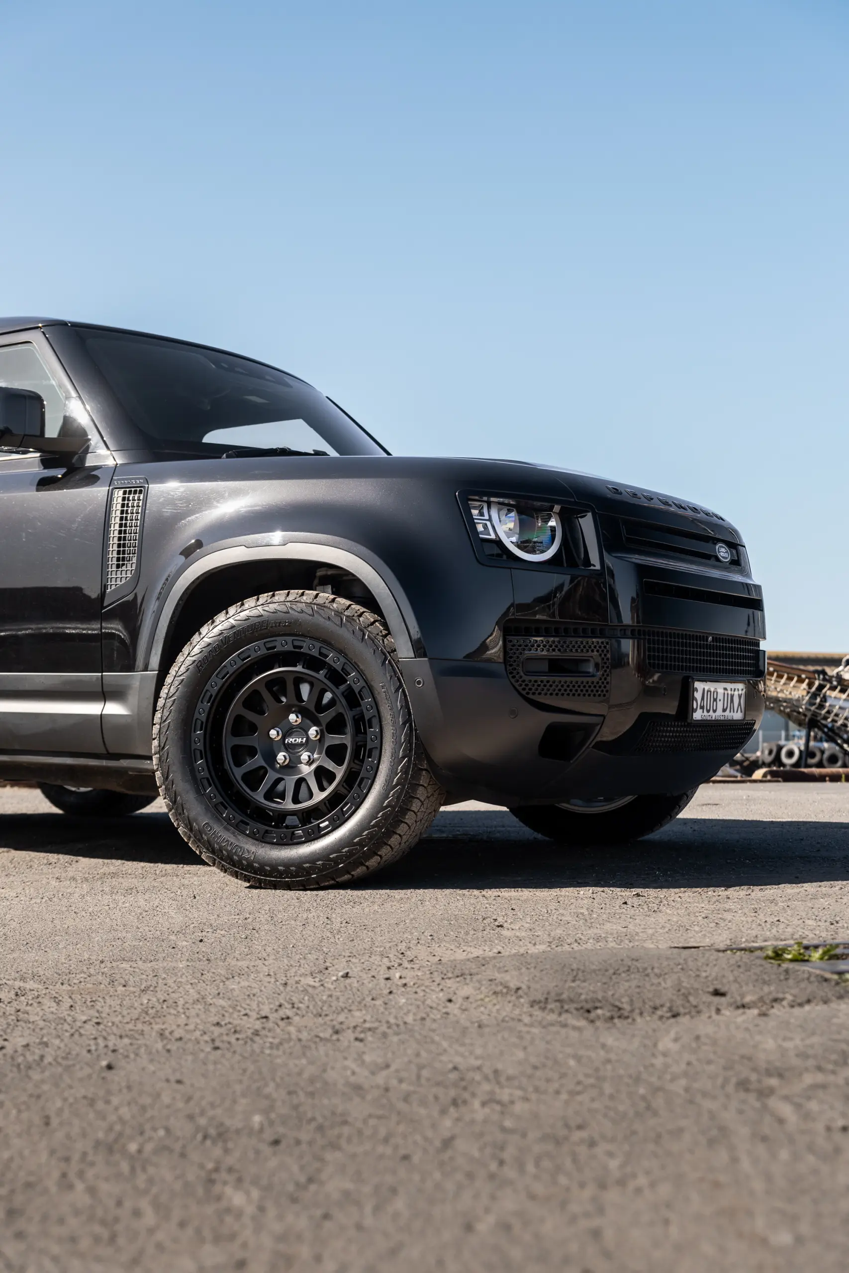 Black Land Rover Defender 90 with 20x9 +22 5x120 Matte Black ROH Assault Wheels at dockyard