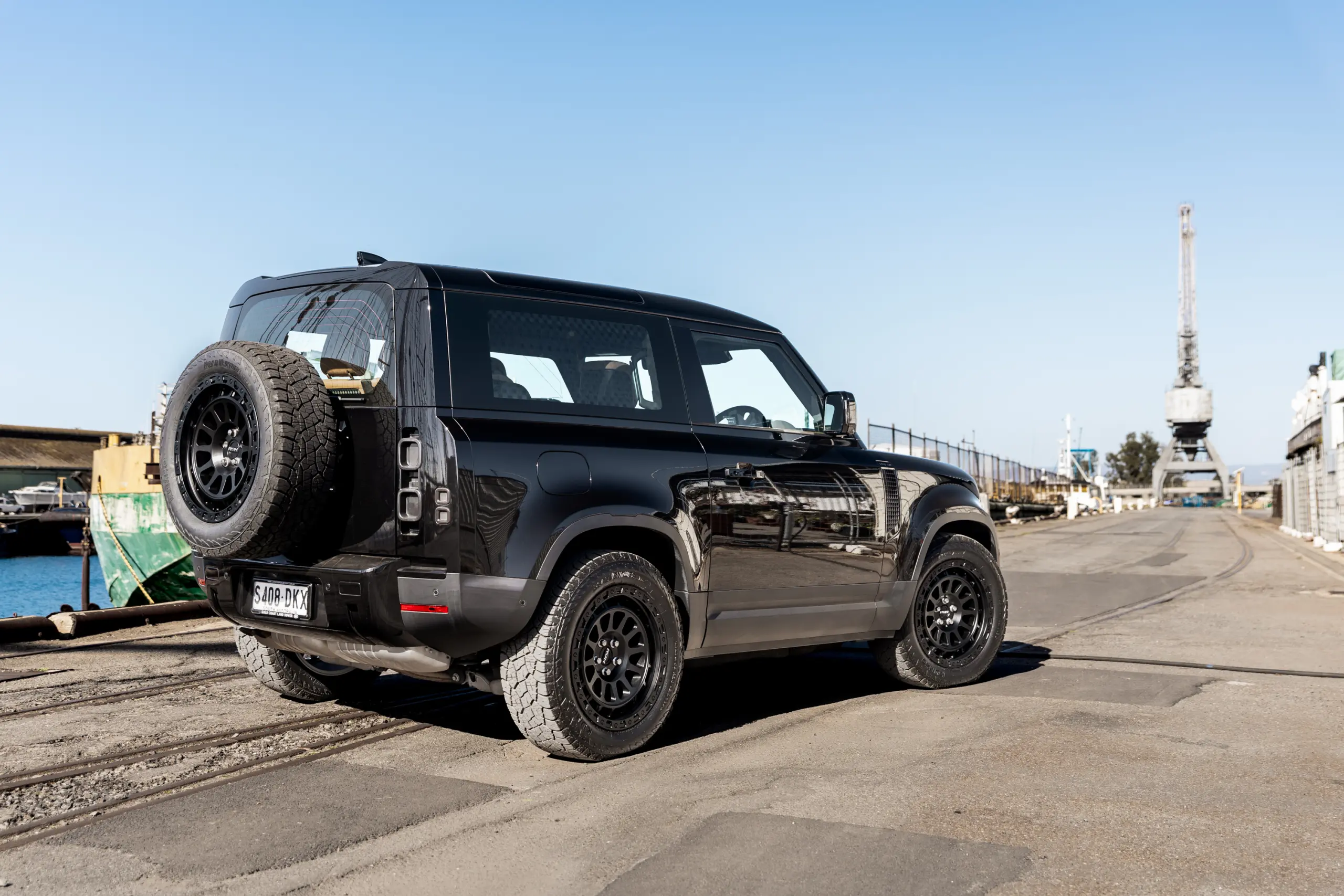Black Land Rover Defender 90 with 20x9 +22 5x120 Matte Black ROH Assault Wheels at dockyard