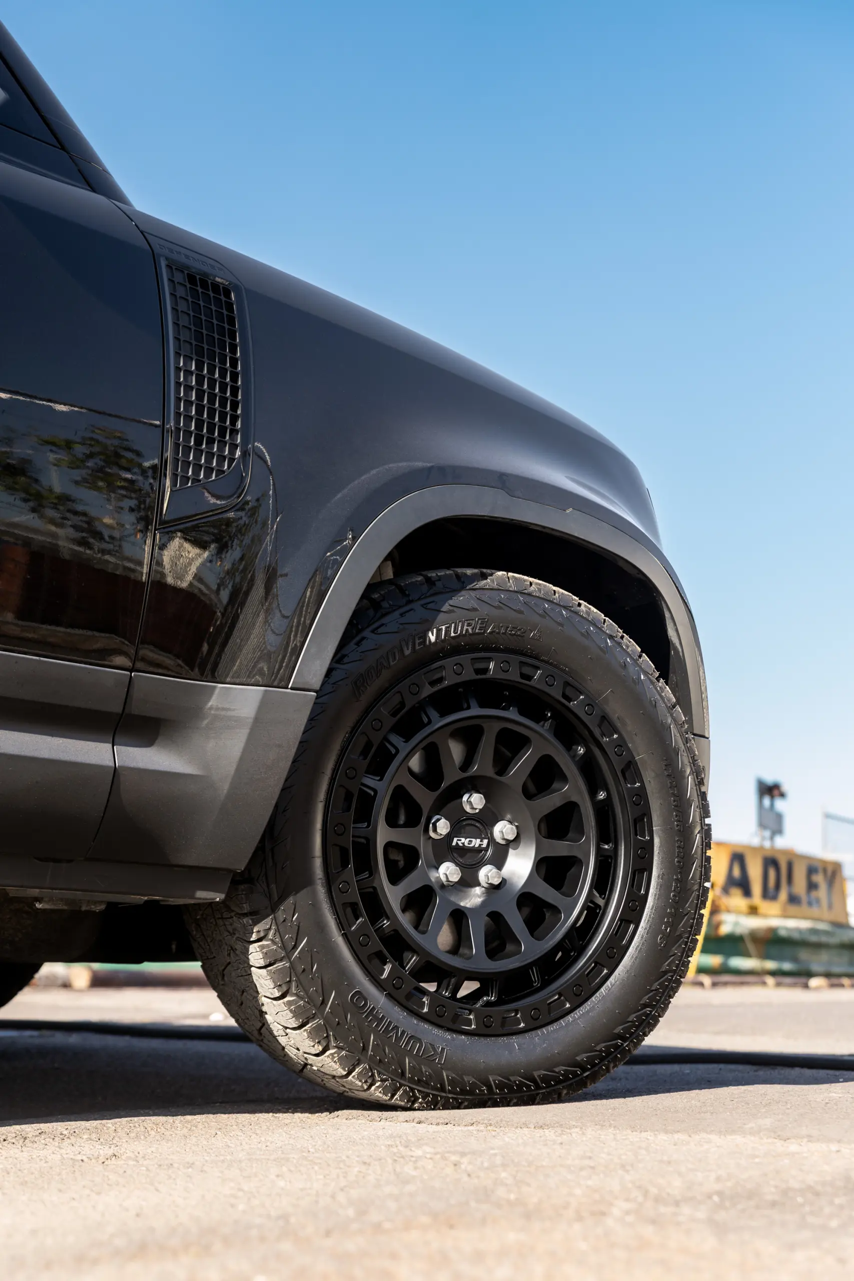 Black Land Rover Defender 90 with 20x9 +22 5x120 Matte Black ROH Assault Wheels at dockyard