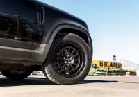 Black Land Rover Defender 90 with 20x9 +22 5x120 Matte Black ROH Assault Wheels at dockyard