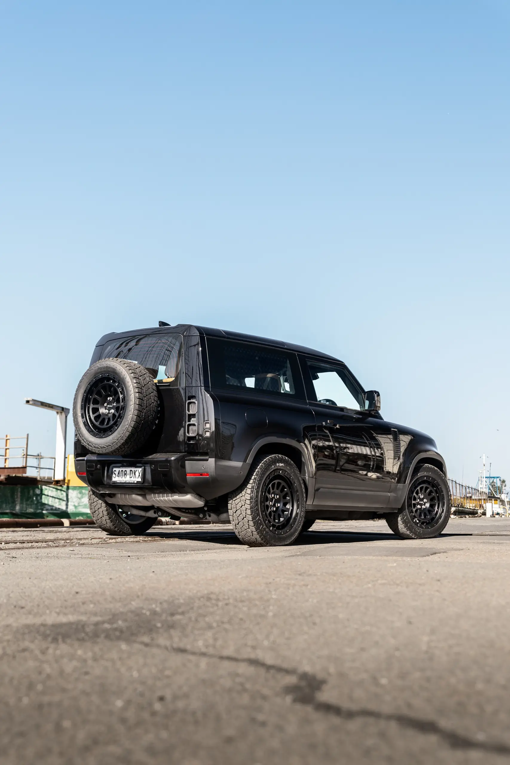 Black Land Rover Defender 90 with 20x9 +22 5x120 Matte Black ROH Assault Wheels at dockyard