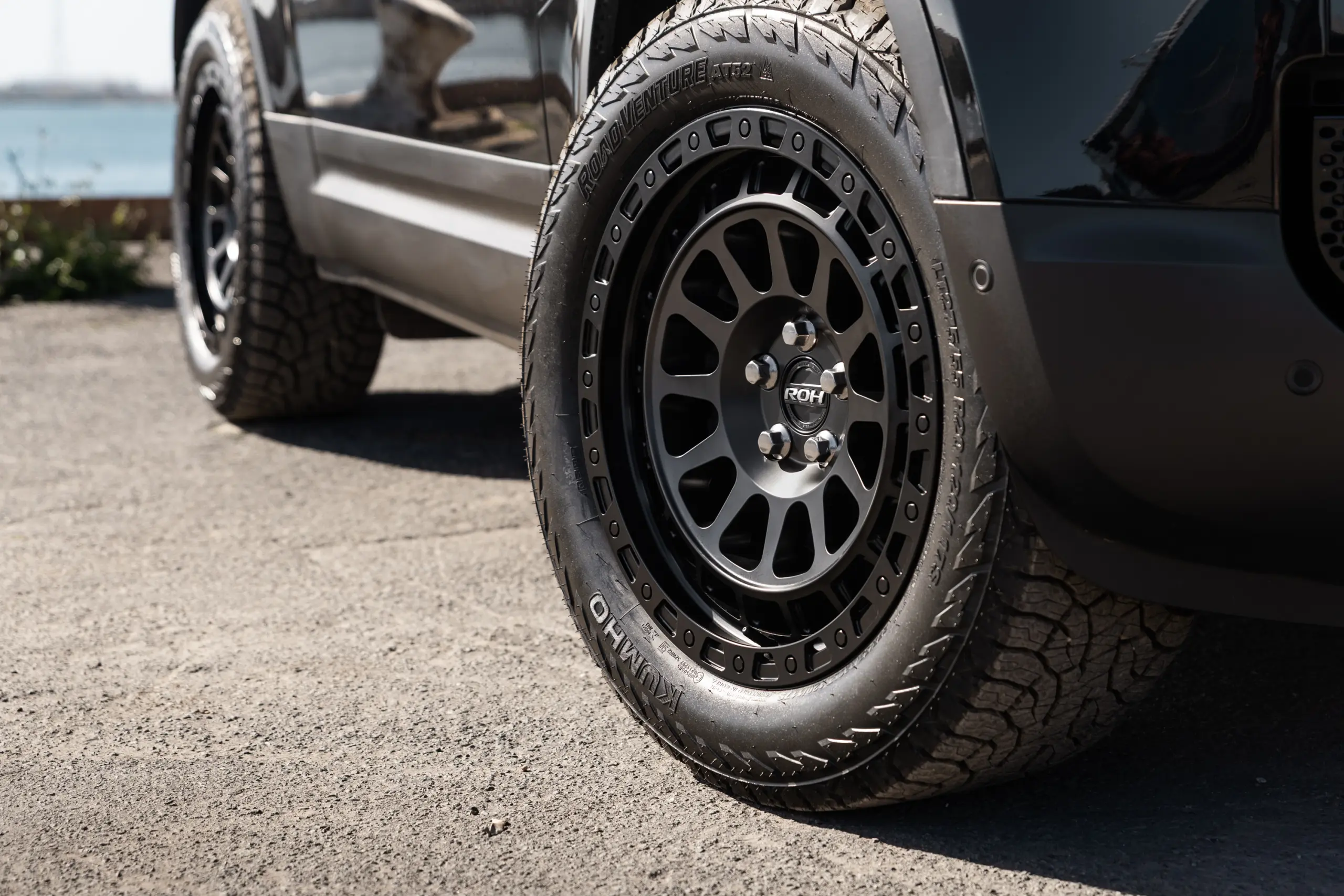 Black Land Rover Defender 90 with 20x9 +22 5x120 Matte Black ROH Assault Wheels at dockyard