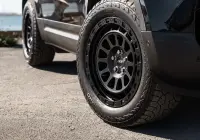 Black Land Rover Defender 90 with 20x9 +22 5x120 Matte Black ROH Assault Wheels at dockyard
