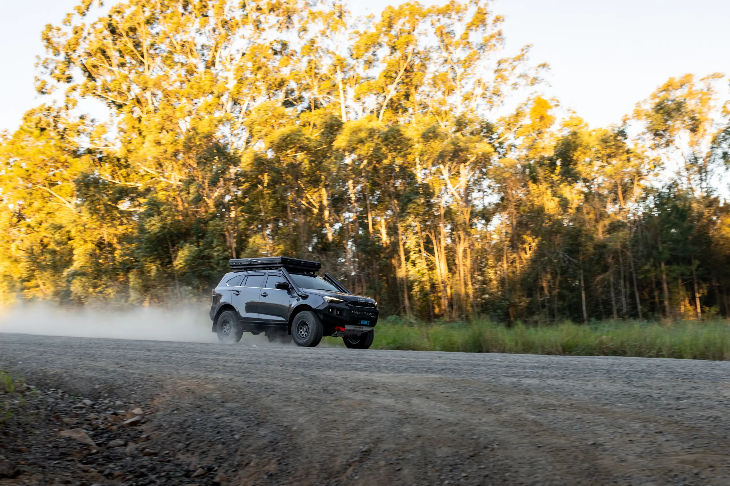 Grey Isuzu MU-X with ROH Atlas 4x4 Wheel in Graphite Centre Black Lip finish driving on dusty gravel road