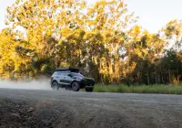 Grey Isuzu MU-X with ROH Atlas 4x4 Wheel in Graphite Centre Black Lip finish driving on dusty gravel road