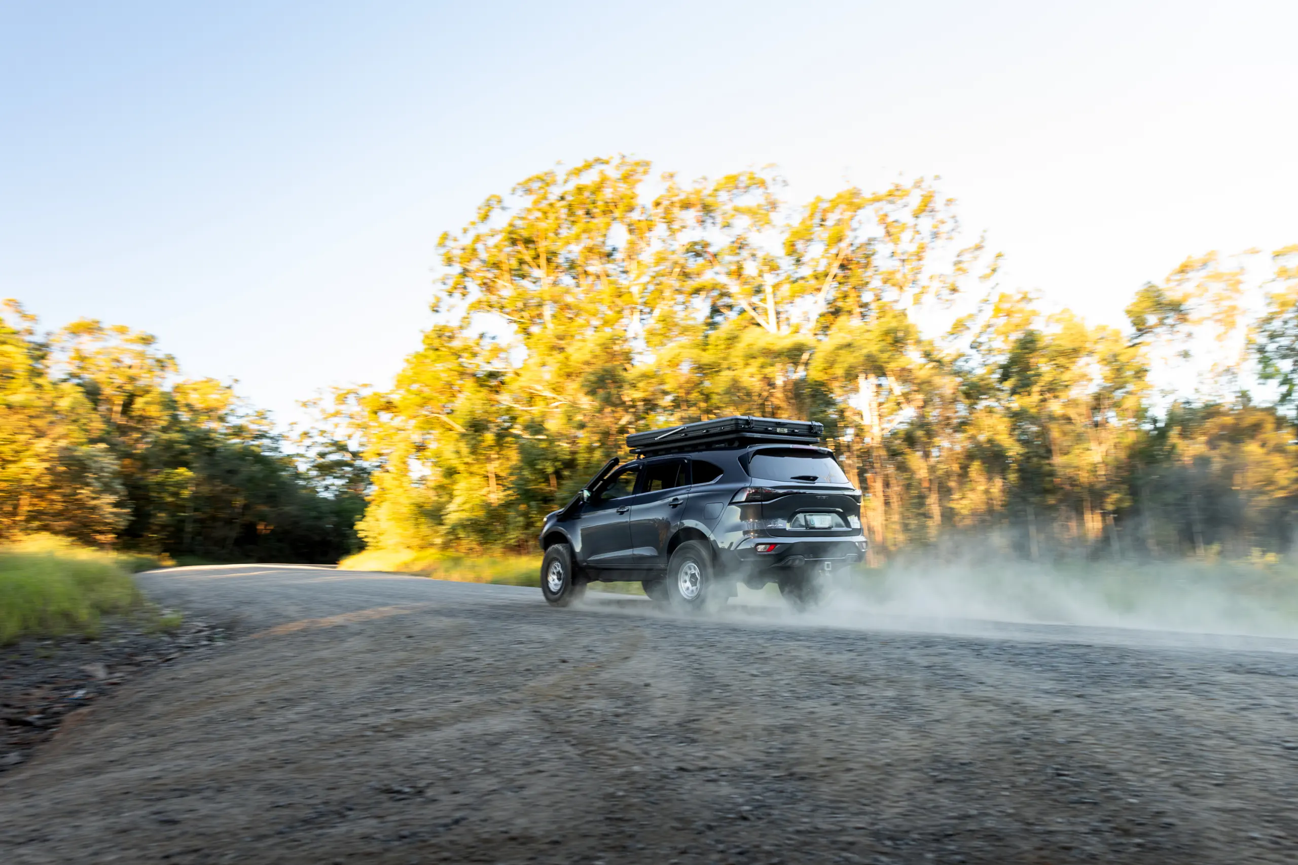 Grey Isuzu MU-X with ROH Atlas 4x4 Wheel in Machined Centre Black Lip finish on gravel road in dust