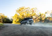 Grey Isuzu MU-X with ROH Atlas 4x4 Wheel in Machined Centre Black Lip finish on gravel road in dust