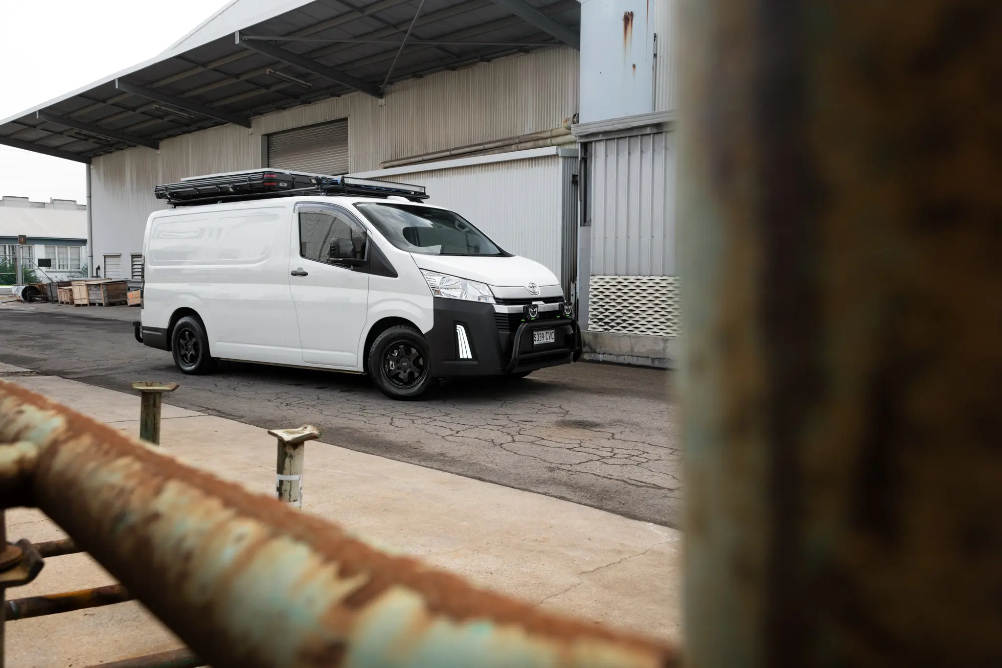 Toyota HiAce H300 Van with ROH Torque Matte Black Wheels in industrial area