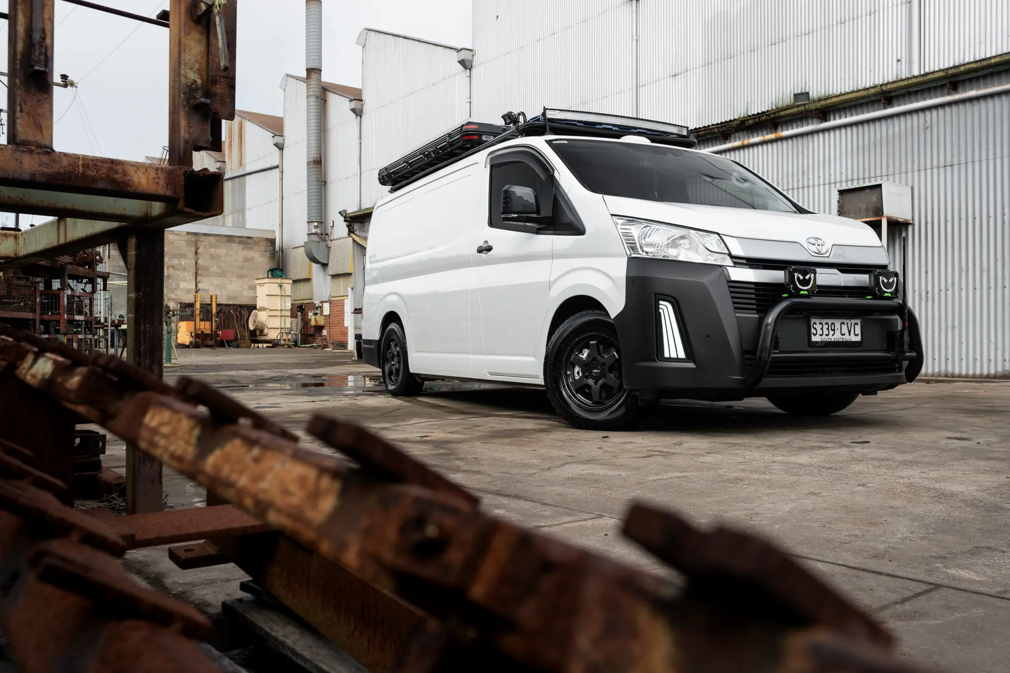 Toyota HiAce H300 Van with ROH Torque Matte Black Wheels in industrial area