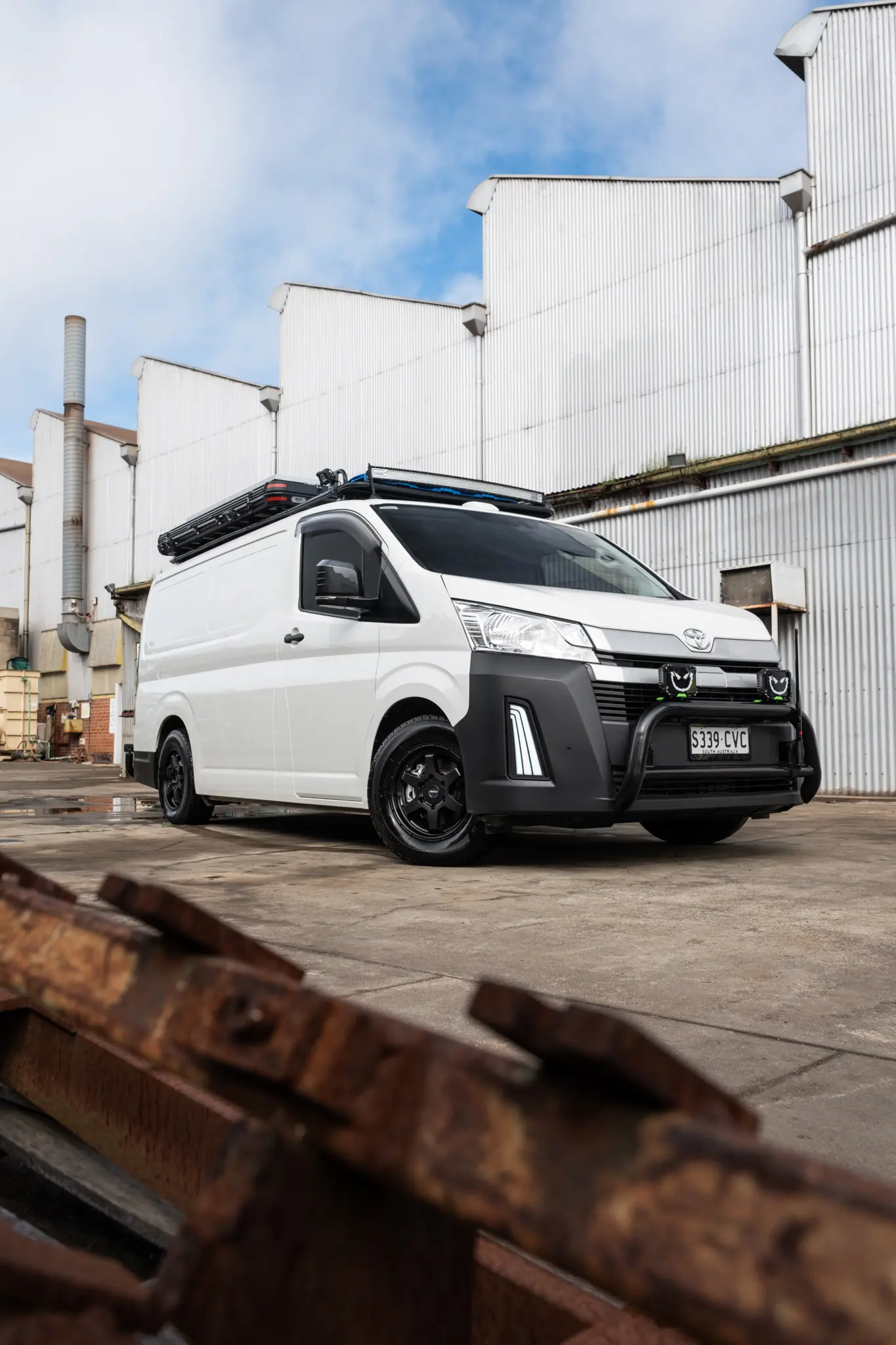 Toyota HiAce H300 Van with ROH Torque Matte Black Wheels in industrial area