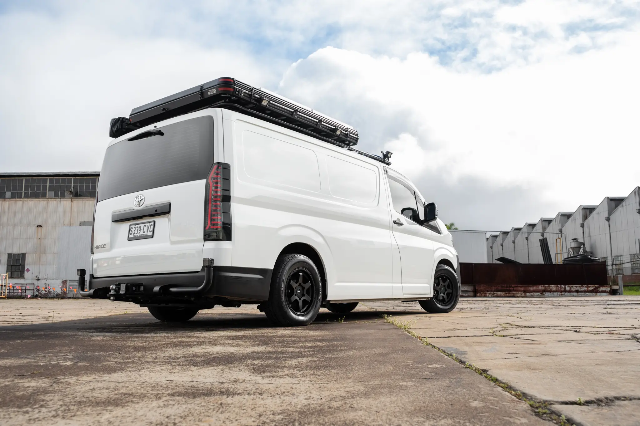 Toyota HiAce H300 Van with ROH Torque Matte Black Wheels in industrial area