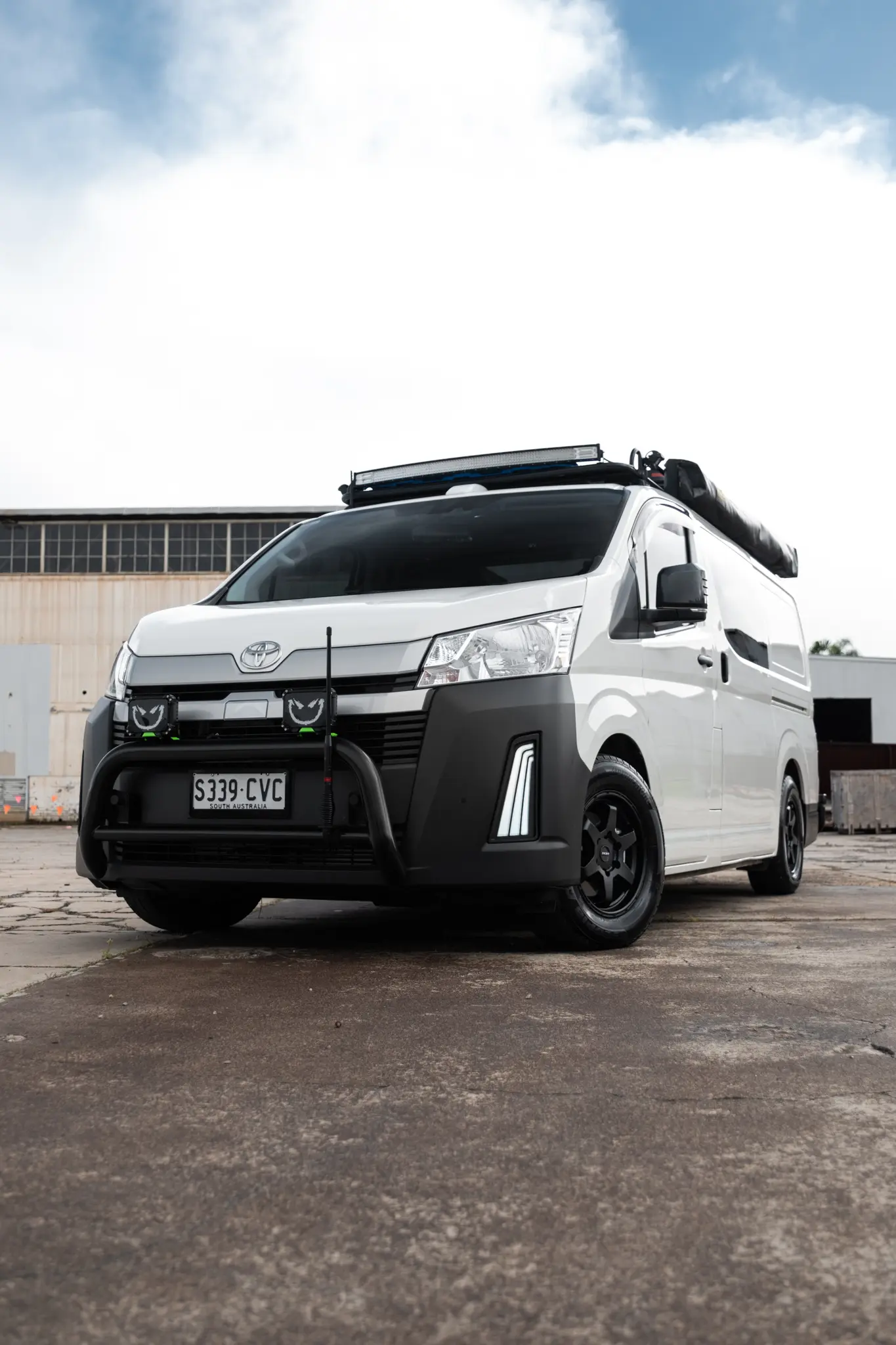 Toyota HiAce H300 Van with ROH Torque Matte Black Wheels in industrial area