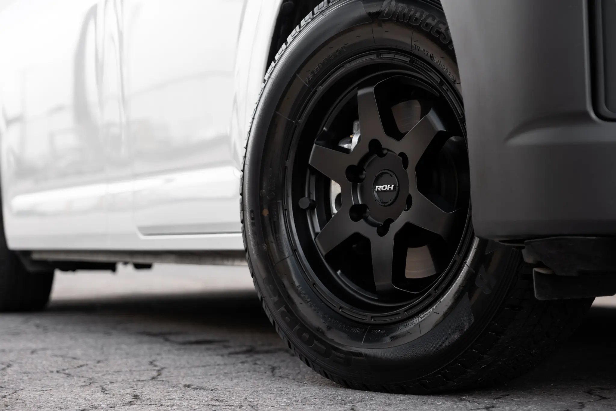 Toyota HiAce H300 Van with ROH Torque Matte Black Wheels in industrial area