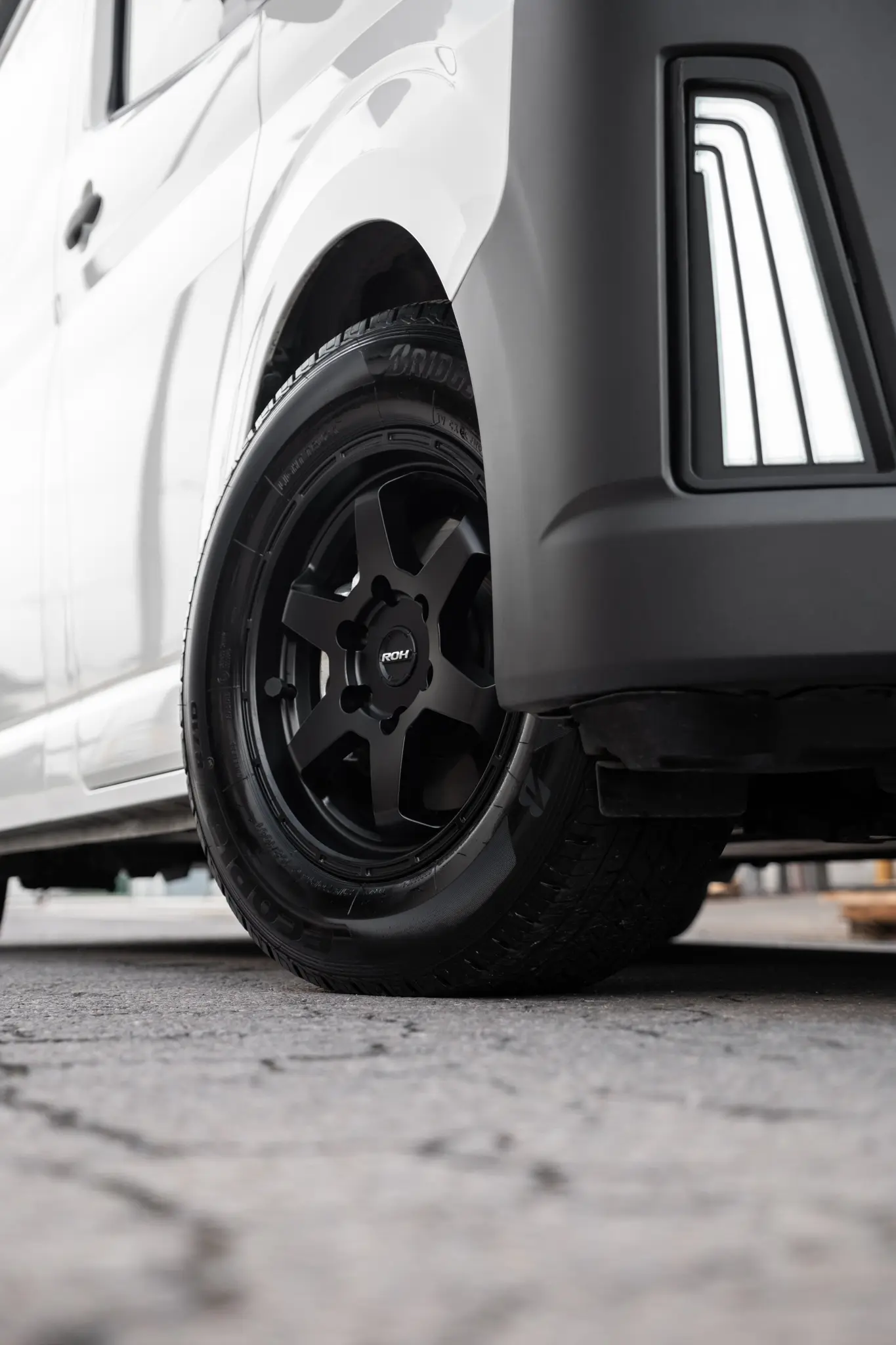 Toyota HiAce H300 Van with ROH Torque Matte Black Wheels in industrial area