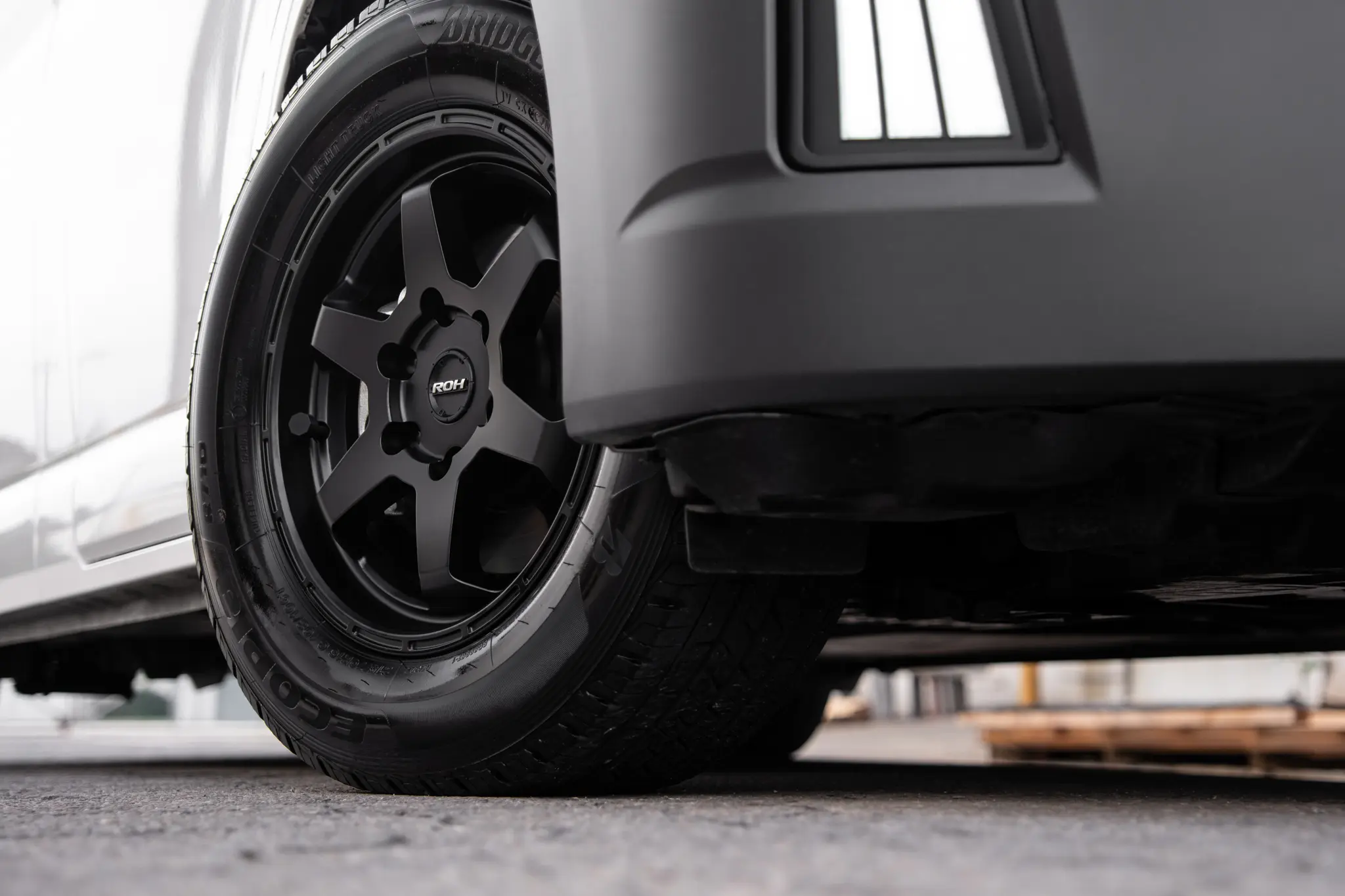Toyota HiAce H300 Van with ROH Torque Matte Black Wheels in industrial area