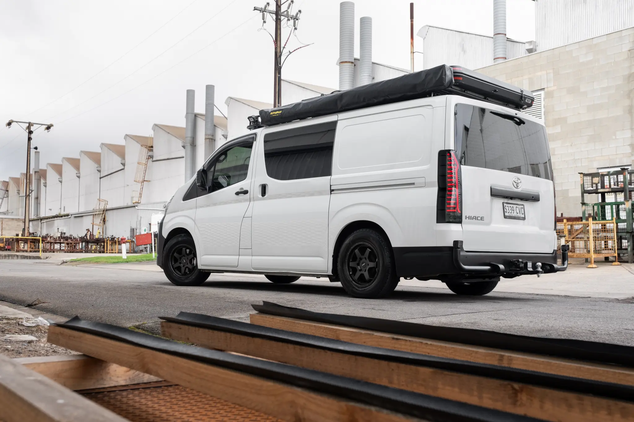 Toyota HiAce H300 Van with ROH Torque Matte Black Wheels in industrial area