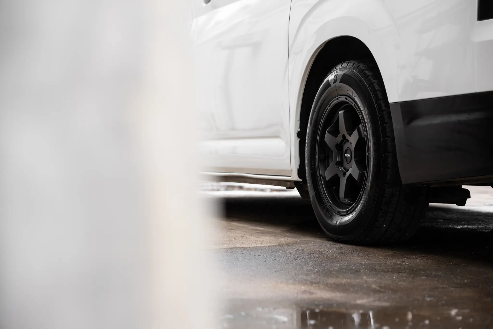 Toyota HiAce H300 Van with ROH Torque Matte Black Wheels in industrial area