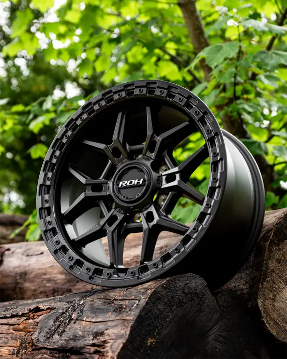 ROH Axe Matte Black 4x4 Alloy Wheel on wood logs