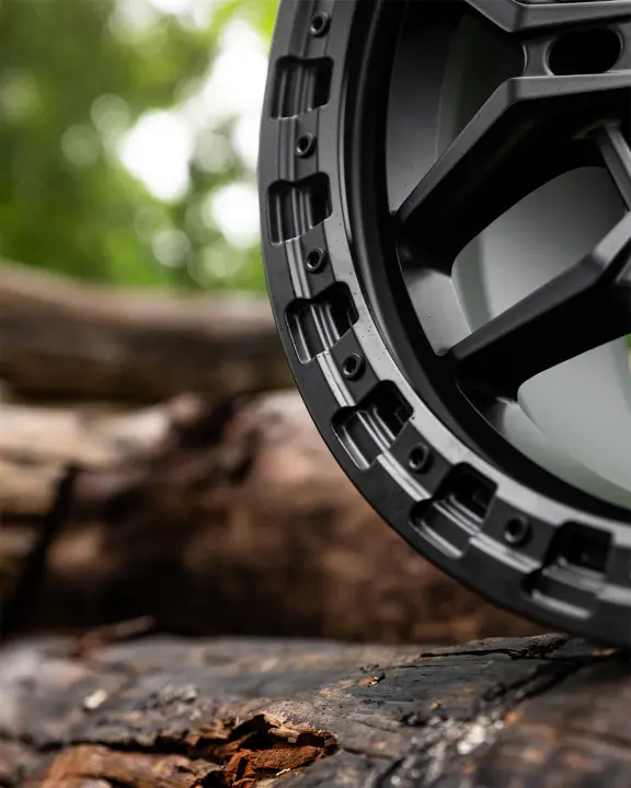 Close Up Image of ROH Axe Matte Black 4x4 Alloy Wheel on wood logs