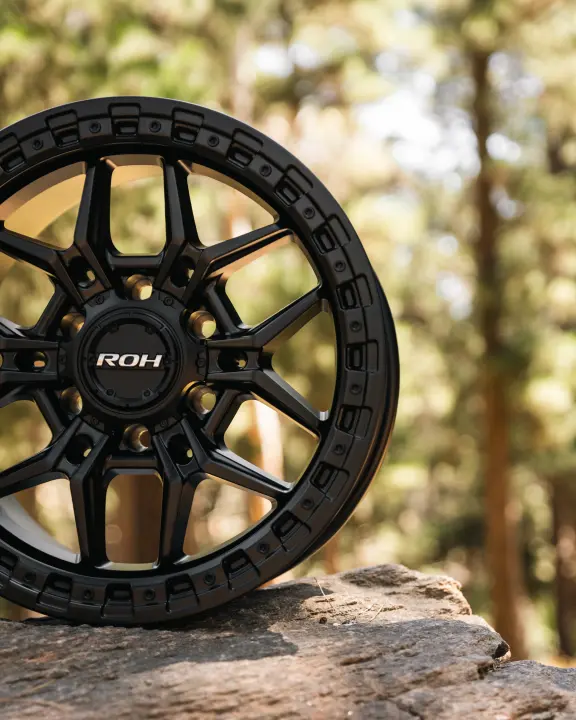 ROH Axe Matte Black 4x4 Alloy Wheel on forest rocks